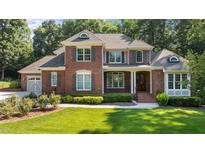 Charming two-story brick home featuring a well-manicured lawn, classic shutters, and inviting front entrance at 1028 Harpers Ridge Ct, Wake Forest, NC 27587