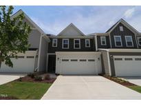 Charming townhome with attached two-car garage and a concrete driveway at 1218 Tredenham Way, Durham, NC 27703