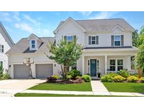 Charming two-story home featuring a landscaped front yard, a teal front door and an attached two-car garage at 1502 Spring Overlook Ln, Hillsborough, NC 27278