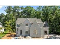 A charming new construction home with grey painted brick, gabled roof, and ample windows at 1529 Lake Adventure Ct, Raleigh, NC 27613