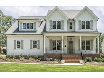 Inviting two-story home showcasing a classic facade, landscaped lawn, and brick-lined front porch at 201 S Ennis St, Fuquay Varina, NC 27526