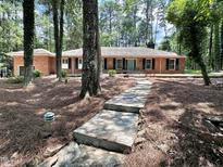 Charming brick home with blue door and lush surrounding greenery at 207 Wood Cir, Chapel Hill, NC 27514