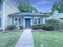 Charming home with blue shutters, manicured hedges, and walkway to the front door at 27 Stonewall Way, Durham, NC 27704