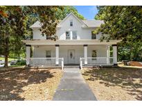Charming white two-story home with a welcoming front porch and well-maintained landscaping at 347 W Trade St, Burlington, NC 27217