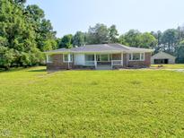 Charming brick ranch with a blue front door and a spacious front yard at 4414 Nc Hwy 87 N, Pittsboro, NC 27312