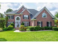 Beautiful two-story brick home with manicured lawn and lush landscaping at 500 Walcott Way, Cary, NC 27519