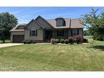 Charming home featuring manicured lawn, well-kept landscaping, and an attached two-car garage at 54 Tucker Farm Cir, Angier, NC 27501