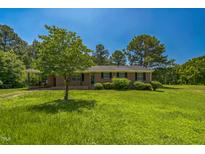 Charming one-story brick home with lush lawn and mature landscaping at 605 Sagefield Way, Henderson, NC 27537