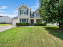 Charming two-story home featuring a well-manicured lawn and welcoming curb appeal with mature tree and tasteful landscaping at 6228 Saybrooke Dr, Raleigh, NC 27604