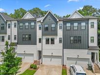 Modern townhome featuring a gray and white color scheme and an attached two-car garage at 907 Lake Beacon Way, Raleigh, NC 27606