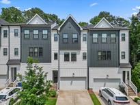 Charming townhome showcases a two-tone color scheme, complemented by individual garages and well-maintained landscaping at 907 Lake Beacon Way, Raleigh, NC 27606