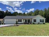 Charming single-story home featuring a two-car garage and well-manicured lawn at 956 W Greensboro Chapel Hill Rd, Snow Camp, NC 27349