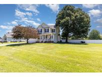Charming two-story home featuring a lush green lawn and a welcoming front porch at 114 Boone Trl, Garner, NC 27529