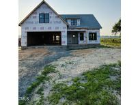 New construction home with an attached two-car garage, front porch, and black window frames at 1327 Parkertown Rd, Four Oaks, NC 27524