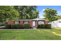 Charming brick home with manicured front yard and mature trees, offering great curb appeal at 163 Lake Latham Rd, Mebane, NC 27302