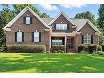 Charming two-story brick home with a manicured lawn and neatly trimmed hedges at 164 Avocet Ln, Clayton, NC 27520