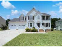 Charming two-story home featuring a three-car garage, manicured lawn and inviting front porch at 17 Ballard Ct, Durham, NC 27712