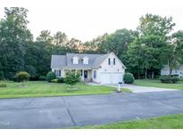 Charming two-story home with manicured lawn, two-car garage, and surrounded by lush trees at 237 Water Front Ln, Timberlake, NC 27583