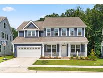 Charming two-story home featuring blue siding, a welcoming front porch, and a convenient attached two-car garage at 2720 Spotted Coral Ct, Apex, NC 27502
