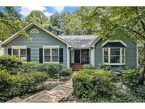 Charming home featuring a stone pathway and lush greenery leading to the inviting front entrance at 311 Westbrook Dr, Carrboro, NC 27510