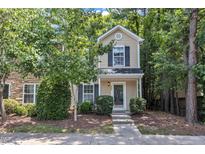 Charming two-story home with tan siding, lush landscaping, and a welcoming front entrance at 3352 Tarleton W, Durham, NC 27713
