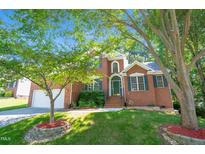 Inviting brick home featuring well-manicured landscaping and a two-car garage at 5107 Granbury Dr, Durham, NC 27713
