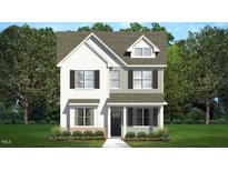 Charming two-story home featuring a mix of white and gray siding, complemented by black shutters and a welcoming front porch at 553 Lemon Daisy Ln, Knightdale, NC 27545