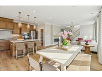 Charming eat-in kitchen features an island with seating, wood cabinets, and stainless steel appliances at 610 Callan View Ave, Wake Forest, NC 27587