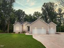 Charming home with a two-car garage, manicured lawn and natural surroundings at 620 Rollins Mill Rd, Holly Springs, NC 27540