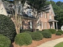A charming brick two-story home with detailed landscaping and a welcoming front porch at 7801 Kingsbrook Ct, Wake Forest, NC 27587