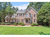 Traditional brick home with manicured lawn and mature trees at 7801 Kingsbrook Ct, Wake Forest, NC 27587