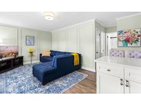Comfortable living room features a blue sectional sofa, decorative rug, and a wall-mounted television at 815 Daniels St # A, Raleigh, NC 27605