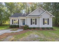 Charming single-story home featuring a blue front door and manicured landscaping at 1008 Alderleaf Dr, Fuquay Varina, NC 27526