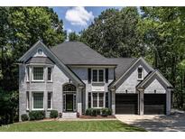 Beautiful gray brick home with a manicured lawn and two-car garage at 104 Warley Cir, Cary, NC 27513