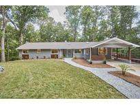 Charming single-story home with a manicured lawn, a welcoming walkway, and an attached carport at 108 Cedar St, Chapel Hill, NC 27514