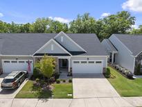Charming single-Gathering home with a gray exterior, manicured lawn, and a two-car garage at 1125 Surveyor Dr, Durham, NC 27703