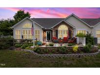 Charming home exterior with stone accents, landscaped yard, and cozy patio seating at 1167 Blue Bird Ln, Wake Forest, NC 27587