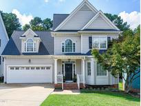 Charming two-story home with a manicured lawn, attached garage, and inviting front porch at 1276 Dalgarven Dr, Apex, NC 27502