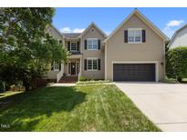 Charming two-story home with a well-manicured lawn, attached garage, and a classic brick-and-siding facade at 2104 Brockfield Ct, Raleigh, NC 27614