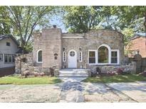 Charming stone home featuring unique architectural details, a well-manicured lawn, and mature trees at 2203 University Dr, Durham, NC 27707