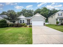 Charming single-story home with a well-manicured lawn and a two-car garage at 3037 Willow Ranch Dr, Fuquay Varina, NC 27526