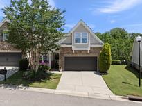 Charming home featuring stone accents, a well-manicured lawn, and an attached two-car garage at 3207 Imperial Oaks Dr, Raleigh, NC 27614