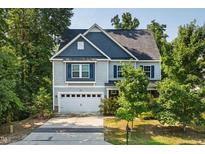 Charming two-story home with a blue and gray exterior, well-maintained lawn, and attached two-car garage at 3401 Grosbeak Way, Raleigh, NC 27616