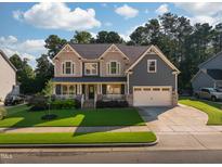 Charming two-story home featuring a manicured lawn, two-car garage and inviting front porch perfect for relaxing at 3624 Regent Pines Dr, New Hill, NC 27562
