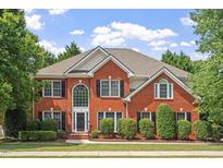 Beautiful two-story brick home with black shutters, manicured lawn, and lush landscaping at 3812 Covina Dr, Raleigh, NC 27613
