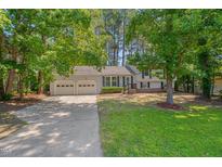 Charming home featuring a well-manicured lawn, a two-car garage, and mature trees at 403 Carpenter Fletcher Rd, Durham, NC 27713