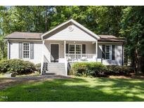 Charming home featuring a quaint front porch, neutral siding, and lush green lawn at 472 Shawnee Dr, Louisburg, NC 27549