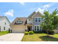 Two-story home with a two-car garage, landscaped yard, and a combination of siding and stone accents at 517 Eagles Way, Mebane, NC 27302