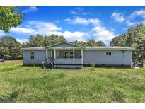 Exterior view of a one-story home with a front porch and grassy yard at 64 Doughty Ln # E, Middlesex, NC 27557