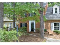 Charming brick townhome with manicured landscaping and inviting front entrance with black door and white trim at 747 Weathergreen Dr, Raleigh, NC 27615